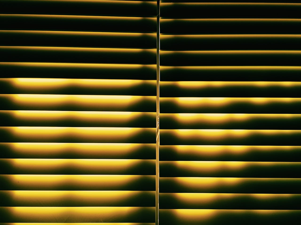 The Art of Drawing Readers In: Your attractive post title goes here A warm, inviting pattern of light through yellow horizontal blinds creates a cozy indoor atmosphere.